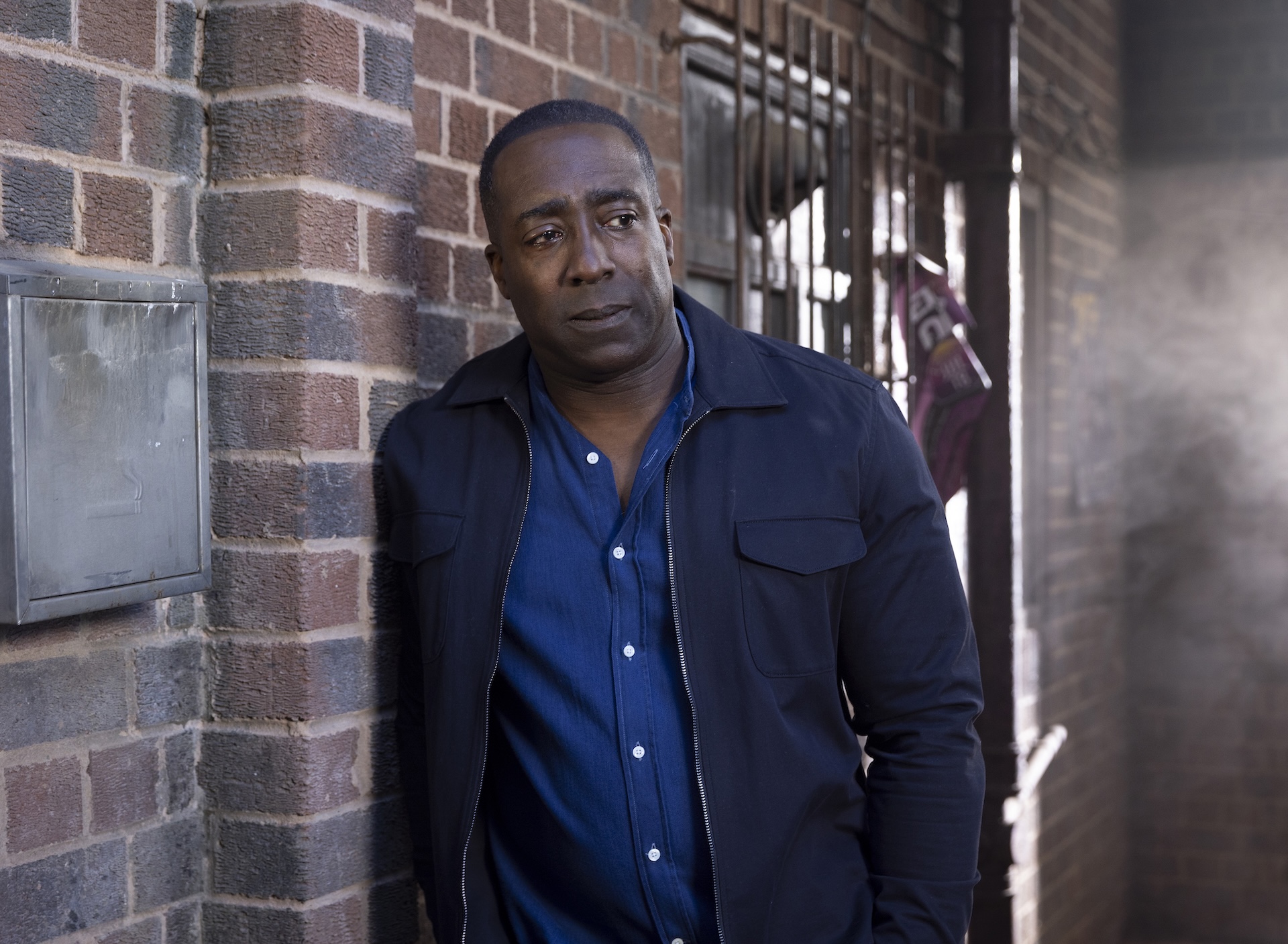 Coronation Street's Ronnie leaning up against a wall